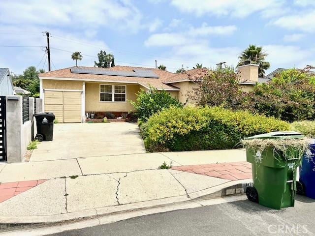 19017 Vanowen St, Reseda, CA 91335 - view of front of property featuring solar panels, stucco siding, and concrete driveway