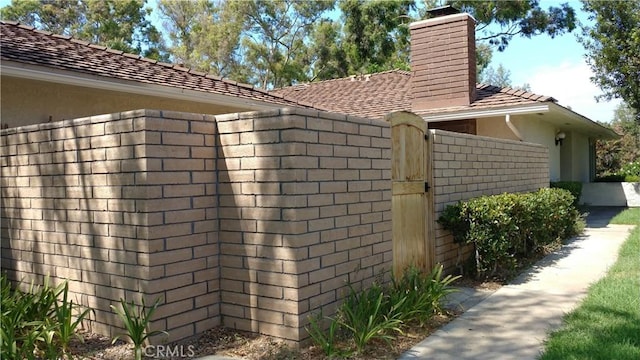 17305 Rosewood, Irvine, CA 92612 - view of side of property with a chimney, stucco siding, and brick siding