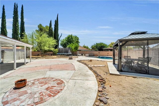 2528 Key Ct, Lancaster, CA 93536 - fenced backyard with a trampoline, a gazebo, and a patio area