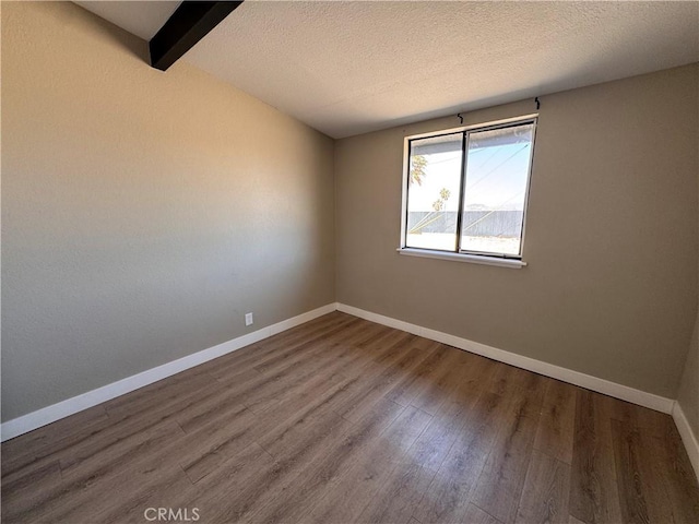 541 Frances Dr, Barstow, CA 92311 - unfurnished room featuring wood finished floors, a textured ceiling, and beamed ceiling