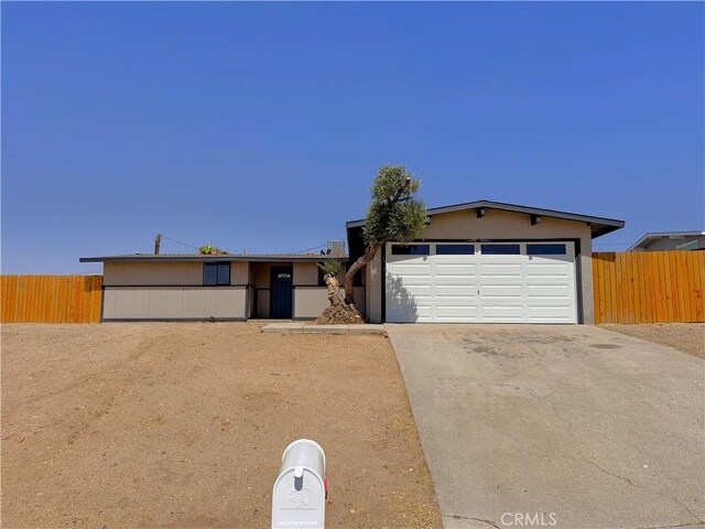 541 Frances Dr, Barstow, CA 92311 - view of front facade with concrete driveway, a garage, and stucco siding