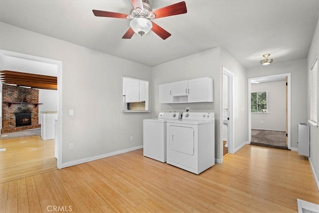 1869 Thrush Rd, Wrightwood, CA 92397 - laundry room featuring cabinet space, washer and clothes dryer, light wood finished floors, a ceiling fan, and a brick fireplace