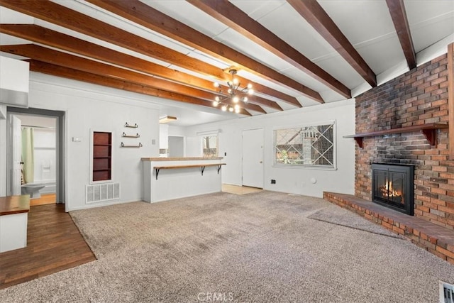 1869 Thrush Rd, Wrightwood, CA 92397 - unfurnished living room featuring a fireplace, beamed ceiling, carpet flooring, and a chandelier
