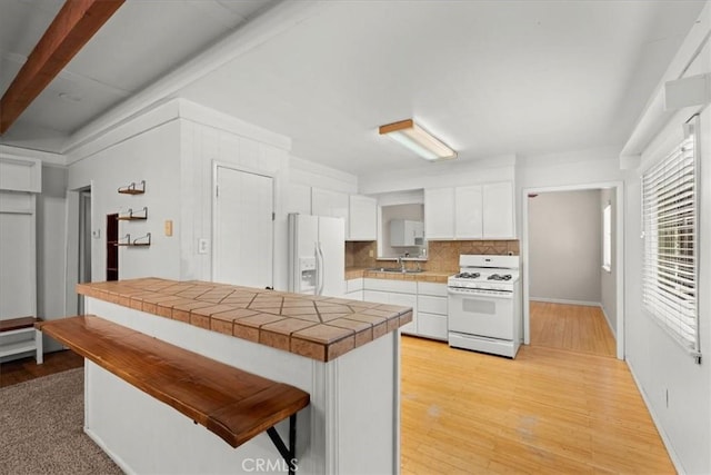 1869 Thrush Rd, Wrightwood, CA 92397 - kitchen with white appliances, white cabinets, backsplash, tile countertops, and light wood-type flooring