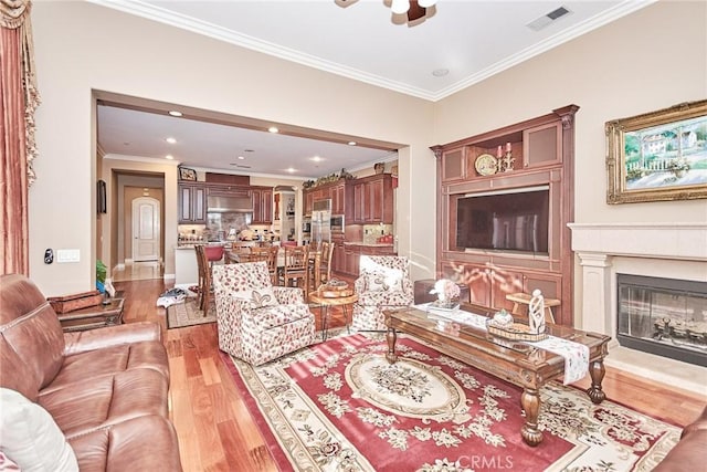 1482 Fergus, Claremont, CA 91711 - living room featuring crown molding, light wood-style flooring, a ceiling fan, recessed lighting, and a glass covered fireplace