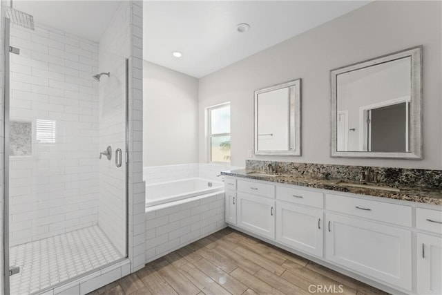 9121 6th Ave, Hesperia, CA 92345 - bathroom featuring a stall shower, double vanity, a bath, and wood finished floors