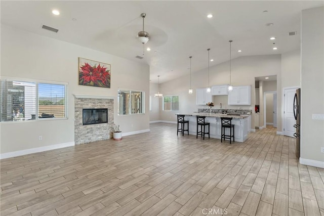 9121 6th Ave, Hesperia, CA 92345 - living area featuring high vaulted ceiling, ceiling fan, light wood-style floors, a fireplace, and recessed lighting