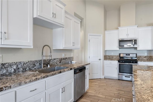 9121 6th Ave, Hesperia, CA 92345 - kitchen featuring appliances with stainless steel finishes, white cabinets, and light wood-style flooring