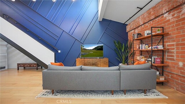 120 S Hewitt St Unit 11, Los Angeles, CA 90012 - living room featuring hardwood / wood-style flooring and brick wall