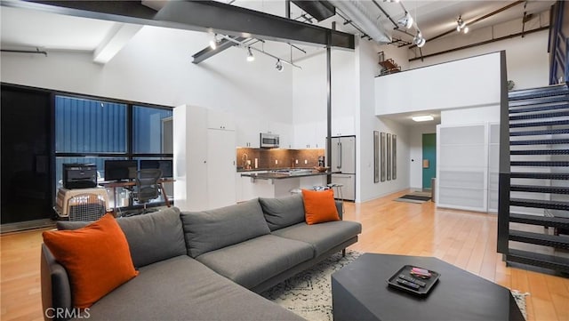 120 S Hewitt St Unit 11, Los Angeles, CA 90012 - living area with light wood finished floors, high vaulted ceiling, and track lighting
