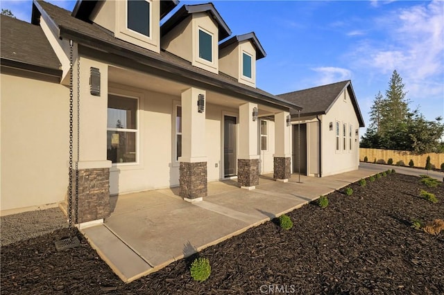 5500 Harrison Rd, Paradise, CA 95969 - rear view of house with stucco siding, stone siding, a porch, and roof with shingles