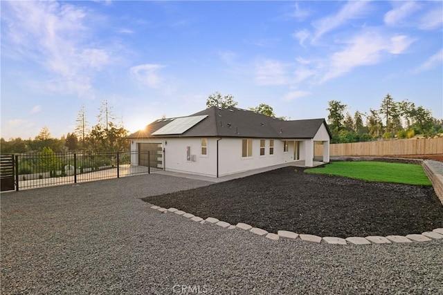 5500 Harrison Rd, Paradise, CA 95969 - rear view of property featuring solar panels, driveway, a patio, a fenced backyard, and an attached garage