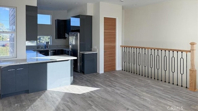1296 Saratoga Ave, Grover Beach, CA 93433 - kitchen featuring freestanding refrigerator, light wood-style floors, a peninsula, light countertops, and modern cabinets