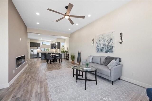 1296 Saratoga Ave, Grover Beach, CA 93433 - living area featuring light wood-style flooring, a ceiling fan, recessed lighting, and a glass covered fireplace