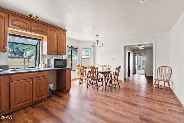 236 S 11th St, Santa Paula, CA 93060 - kitchen featuring black microwave, a chandelier, wood finished floors, and brown cabinetry
