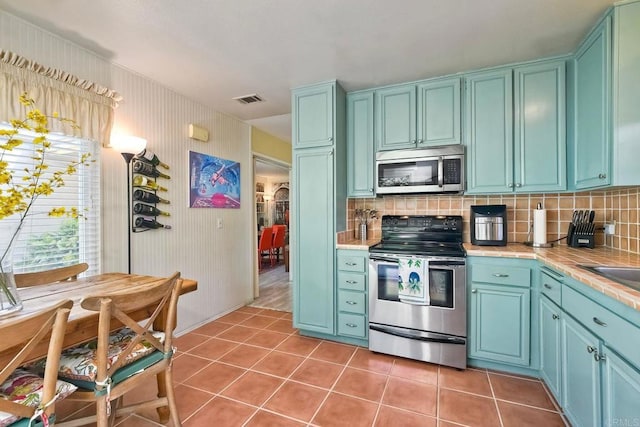 6548 Camino Del Parque, Carlsbad, CA 92011 - kitchen featuring stainless steel appliances, tile countertops, decorative backsplash, and light tile patterned flooring