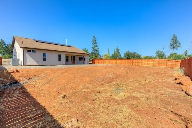 1910 Crandall Way, Paradise, CA 95969 - back of property with roof mounted solar panels, stucco siding, and a fenced backyard