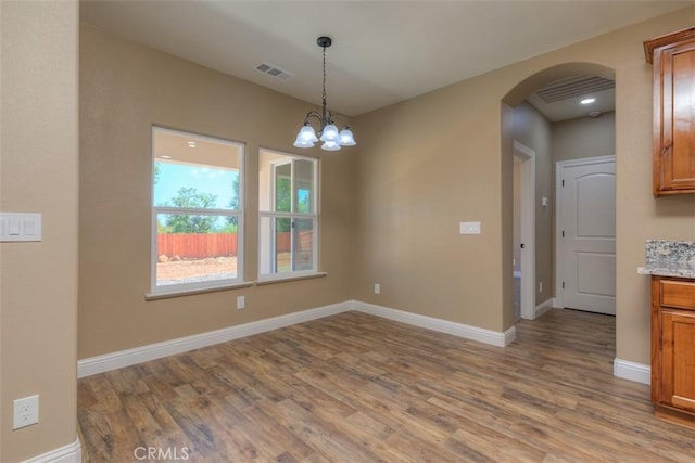 1910 Crandall Way, Paradise, CA 95969 - empty room with arched walkways, wood finished floors, and a chandelier