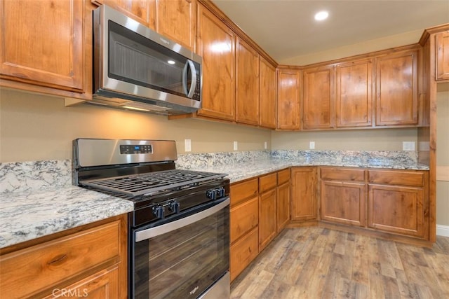 1910 Crandall Way, Paradise, CA 95969 - kitchen with appliances with stainless steel finishes, light wood-style flooring, brown cabinetry, and recessed lighting