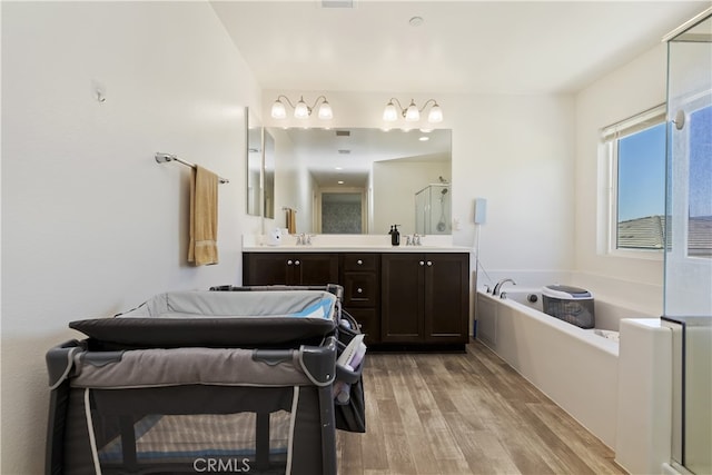 24329 Red Spruce Ave, Murrieta, CA 92562 - full bathroom with wood finished floors, a bath, double vanity, and a stall shower