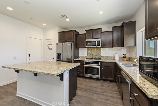 24329 Red Spruce Ave, Murrieta, CA 92562 - kitchen with stainless steel appliances, dark brown cabinetry, a kitchen island, dark wood-style floors, and recessed lighting