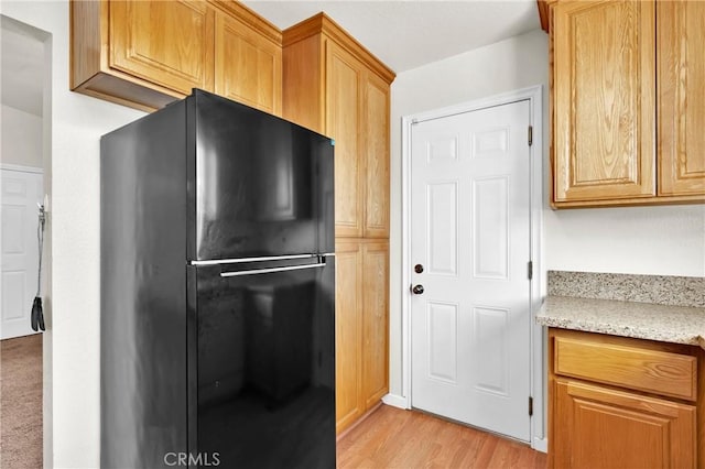 444 Westminister Dr, San Jacinto, CA 92583 - kitchen featuring freestanding refrigerator, light wood-style flooring, and light stone counters