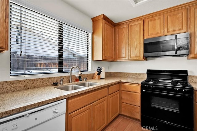 444 Westminister Dr, San Jacinto, CA 92583 - kitchen featuring black gas range oven, stainless steel microwave, white dishwasher, light wood finished floors, and light stone countertops