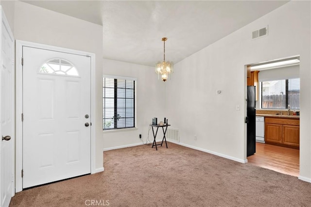 444 Westminister Dr, San Jacinto, CA 92583 - foyer with light carpet, plenty of natural light, and a chandelier