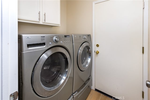 27448 Bridgewater Dr, Valencia, CA 91354 - washroom with washer and dryer, cabinet space, and light wood-type flooring