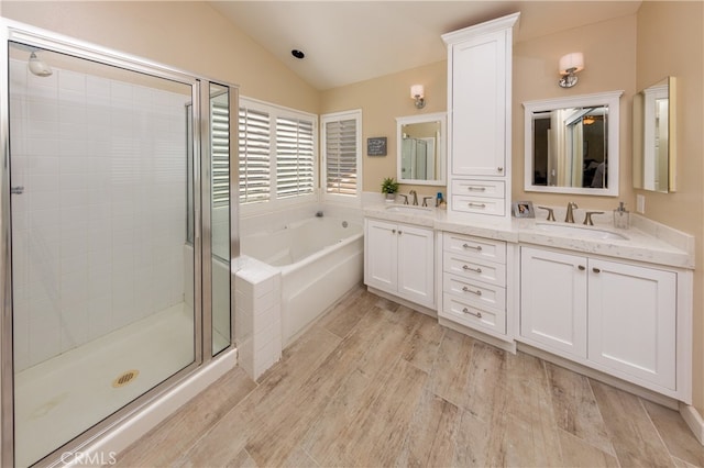 27448 Bridgewater Dr, Valencia, CA 91354 - bathroom with vaulted ceiling, a garden tub, a shower stall, double vanity, and wood finished floors
