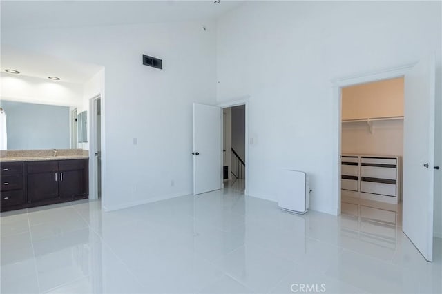 21137 Lassen St Unit 5, Chatsworth, CA 91311 - unfurnished bedroom featuring high vaulted ceiling, light tile patterned floors, a spacious closet, connected bathroom, and a closet