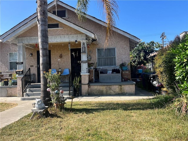 1248 Rolland Curtis Pl, Los Angeles, CA 90037 - view of front facade with stucco siding, a porch, and a front yard