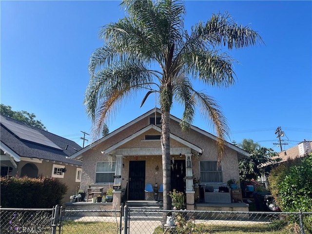 1248 Rolland Curtis Pl, Los Angeles, CA 90037 - view of front of home featuring stucco siding, a fenced front yard, a gate, and a porch