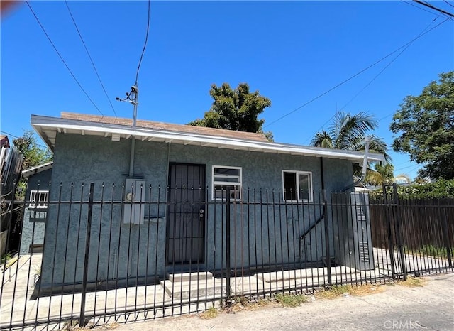 1248 Rolland Curtis Pl, Los Angeles, CA 90037 - view of front of home with stucco siding, a fenced front yard, and a gate