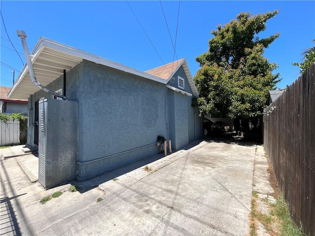 1248 Rolland Curtis Pl, Los Angeles, CA 90037 - view of side of property featuring a patio, stucco siding, and driveway