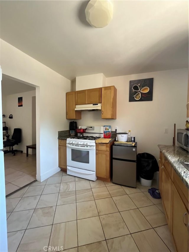 1248 Rolland Curtis Pl, Los Angeles, CA 90037 - kitchen featuring white gas stove, under cabinet range hood, freestanding refrigerator, stainless steel microwave, and light tile patterned floors