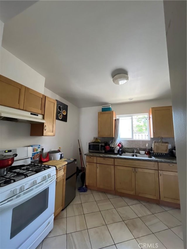 1248 Rolland Curtis Pl, Los Angeles, CA 90037 - kitchen featuring under cabinet range hood, white gas stove, stainless steel microwave, dark countertops, and light tile patterned flooring