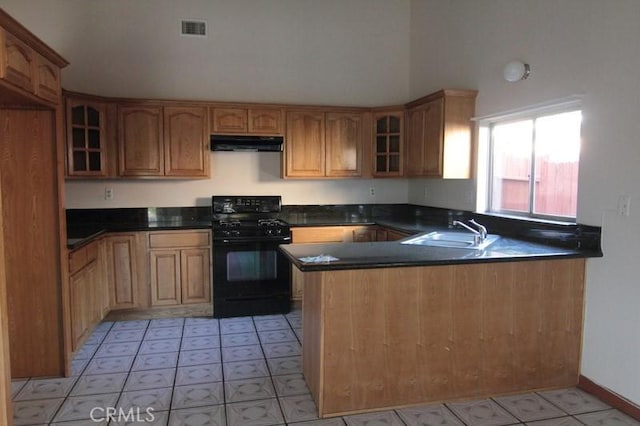 18065 Dorsey Way, Fontana, CA 92335 - kitchen with black range with gas cooktop, under cabinet range hood, a peninsula, glass insert cabinets, and a high ceiling