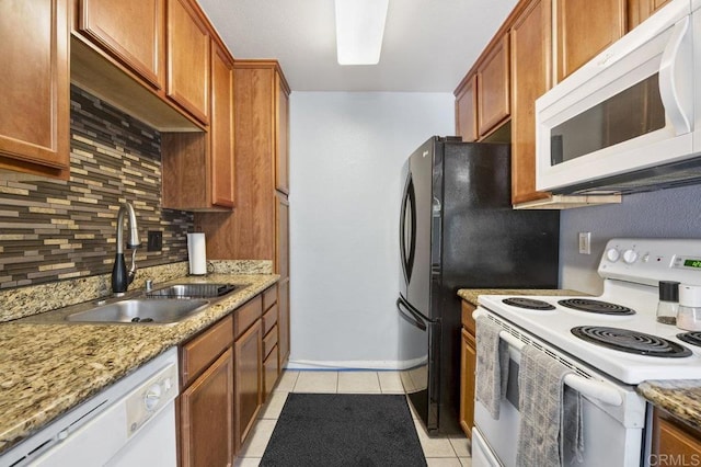 1240 N Broadway Unit 30, Escondido, CA 92026 - kitchen with white appliances, tasteful backsplash, light tile patterned floors, and brown cabinets