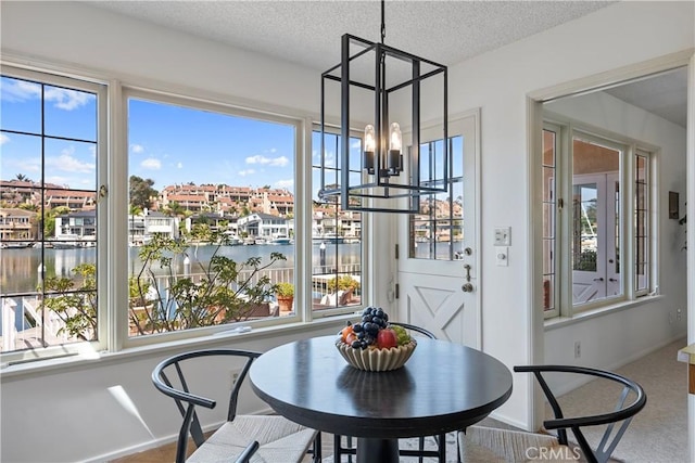 612 Harbor Island Dr, Newport Beach, CA 92660 - dining area featuring a chandelier, healthy amount of natural light, a water view, carpet, and a textured ceiling