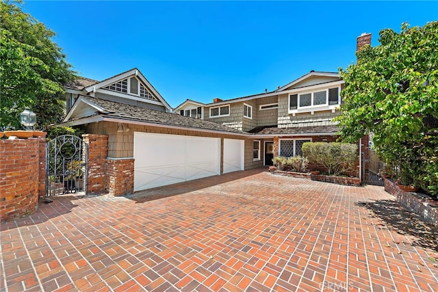 612 Harbor Island Dr, Newport Beach, CA 92660 - view of front of home with a garage, a chimney, decorative driveway, a gate, and brick siding