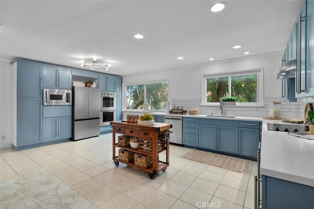 1200 Opal St Unit 7, Redondo Beach, CA 90277 - kitchen with appliances with stainless steel finishes, blue cabinetry, tasteful backsplash, under cabinet range hood, and light countertops