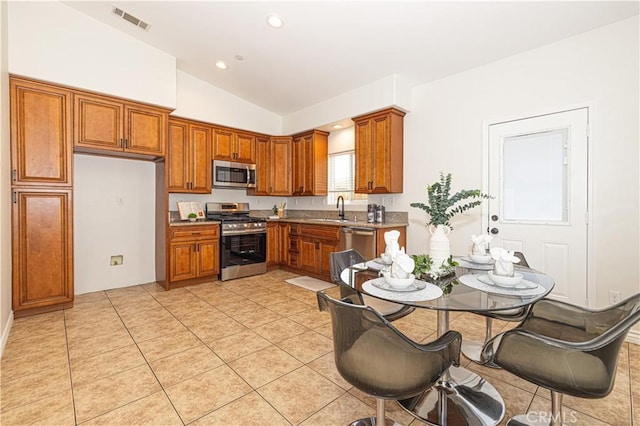 4158 Larchwood Pl, Riverside, CA 92506 - kitchen featuring stainless steel appliances, brown cabinetry, lofted ceiling, light tile patterned floors, and recessed lighting