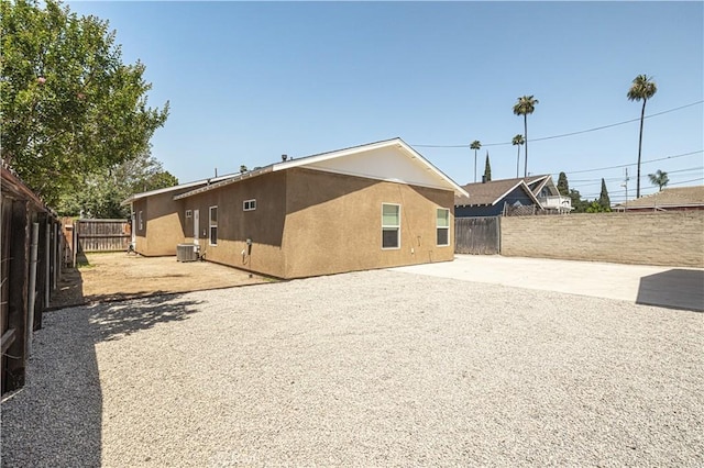 4158 Larchwood Pl, Riverside, CA 92506 - rear view of property featuring a fenced backyard, a patio, gravel driveway, and stucco siding