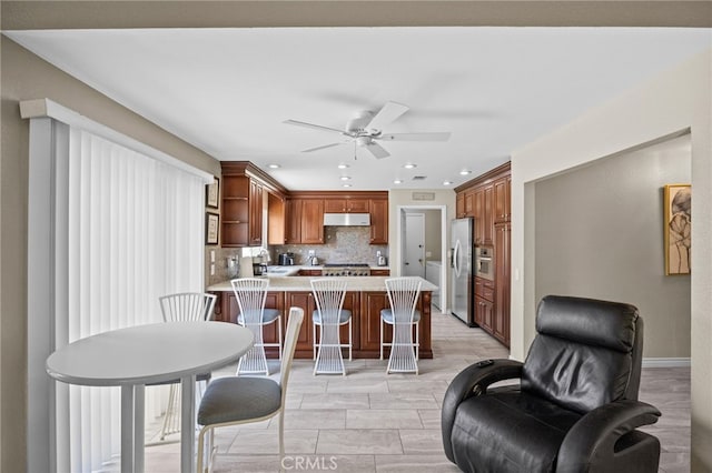 6055 Amethyst Ave, Rancho Cucamonga, CA 91737 - kitchen with stainless steel refrigerator with ice dispenser, under cabinet range hood, a peninsula, backsplash, and open shelves