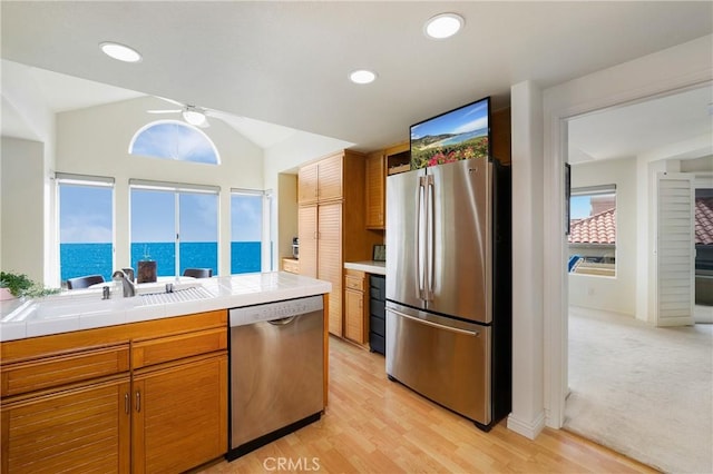 46 Saint Tropez, Laguna Niguel, CA 92677 - kitchen featuring stainless steel appliances, plenty of natural light, brown cabinets, ceiling fan, and lofted ceiling