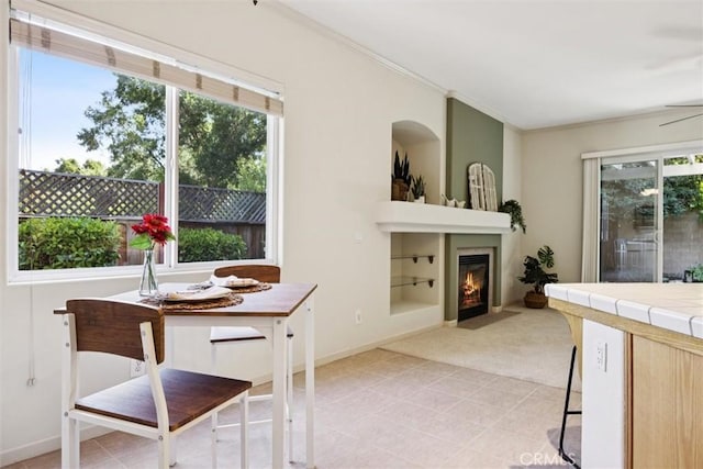 1044 Sleepy Hollow Rd, Paso Robles, CA 93446 - dining area with healthy amount of natural light, ornamental molding, a fireplace with flush hearth, light carpet, and ceiling fan
