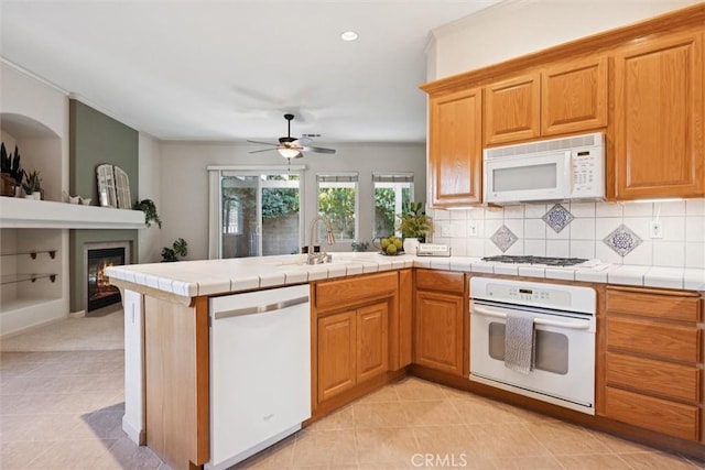 1044 Sleepy Hollow Rd, Paso Robles, CA 93446 - kitchen with white appliances, light tile patterned flooring, ceiling fan, a peninsula, and backsplash