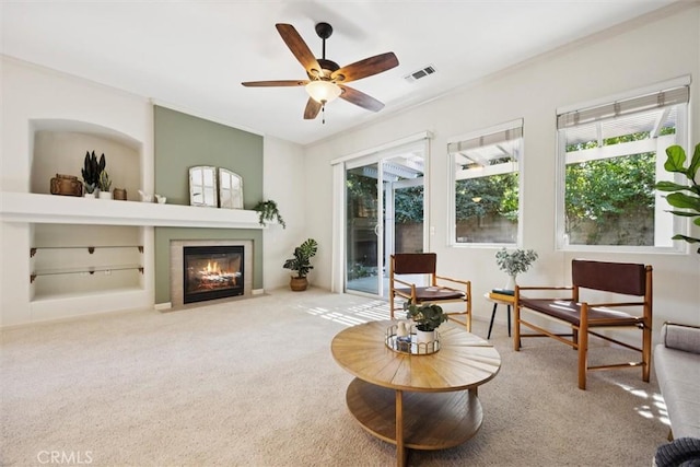 1044 Sleepy Hollow Rd, Paso Robles, CA 93446 - carpeted living room featuring a ceiling fan, a fireplace with flush hearth, crown molding, and built in shelves