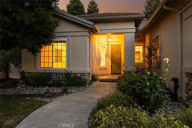 1044 Sleepy Hollow Rd, Paso Robles, CA 93446 - exterior entry at dusk with stucco siding and stone siding
